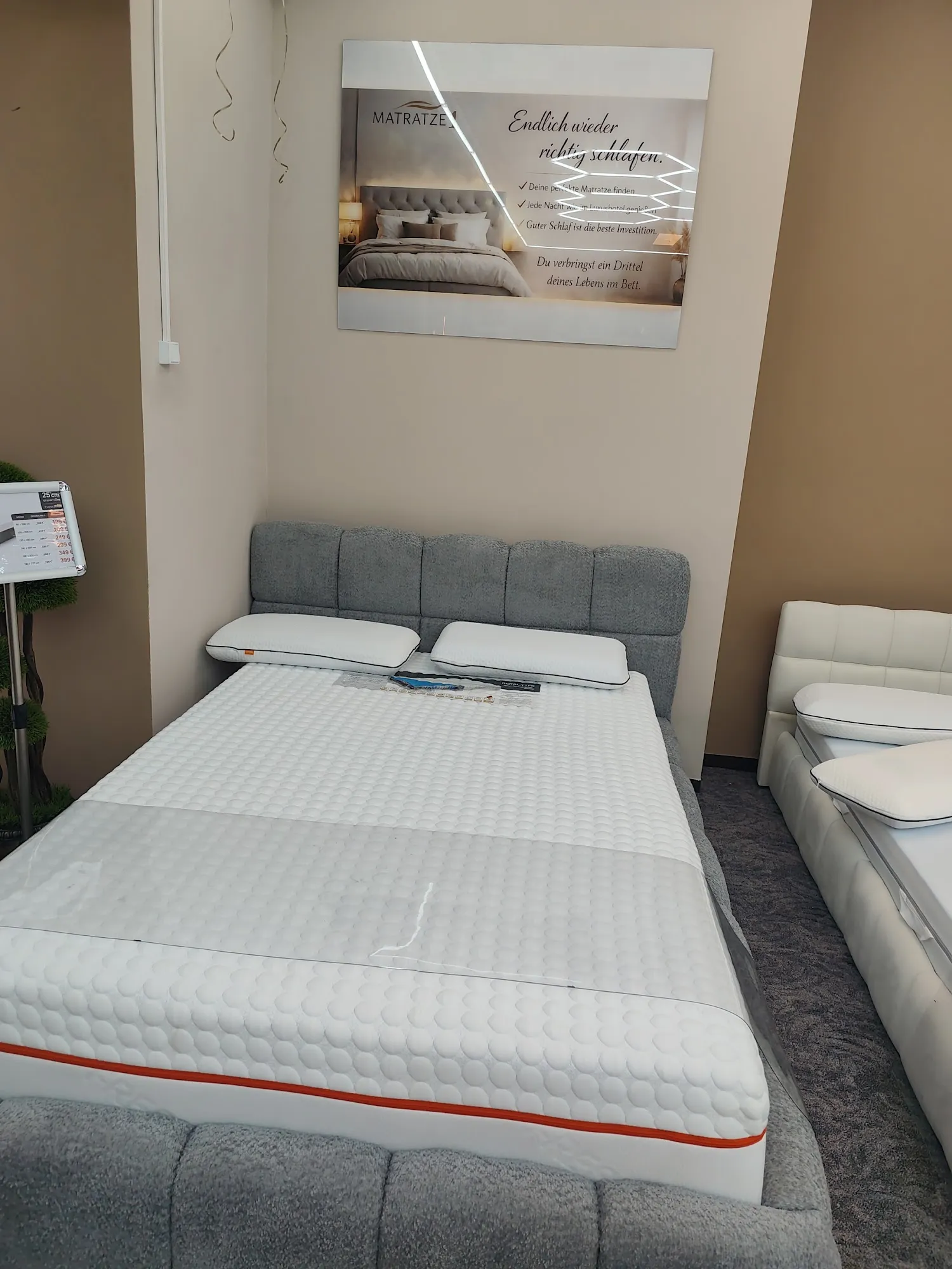 Bett vor dem Wandposter mit dem Satz Endlich wieder richtig schlafen
